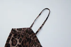 Detailed view of the thin adjustable shoulder strap on a leopard print chiffon dress.