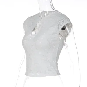 Detail view of white lace crop top featuring a trendy front circular cutout design