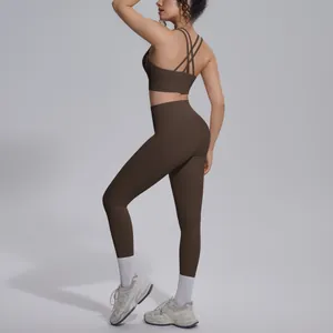 Detailed view of women's brown cross-back sports bra and high-waisted yoga leggings