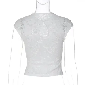 Close-up detail of white lace short top featuring floral patterns and back hollow-out design