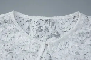 Exquisite close-up detail of white floral lace top neckline featuring sequins and hook closure