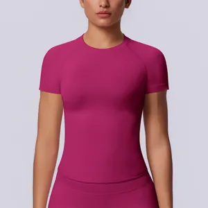 Dettaglio di una maglietta sportiva senza cuciture magenta da donna, ideale per lo yoga.
