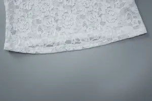 Detailed macro view of white floral lace fabric on a stylish short summer T-shirt for women