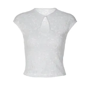 Detail view of the intricate lace texture and keyhole neckline design on the white top