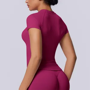 Vista laterale di una t-shirt sportiva senza cuciture color magenta per donna fitness