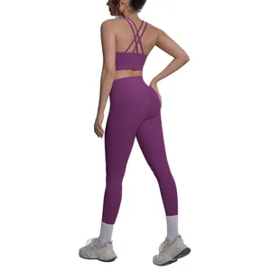 Women's purple two-piece yoga set with crisscross back sports bra and high-waist leggings.