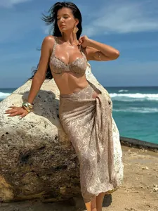 Three-piece beige lace bikini set with matching sarong wrap for beach vacation