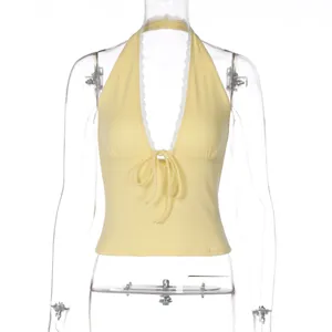 Detail view of yellow halter top with deep V-neck and delicate lace trim