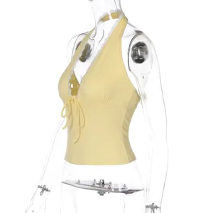 Detailed side view of yellow ribbed halter top featuring lace trim and front tie
