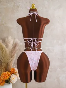 Achteraanzicht van roze bloemen bikini met lovertjes, bandjes en een schelpenketting