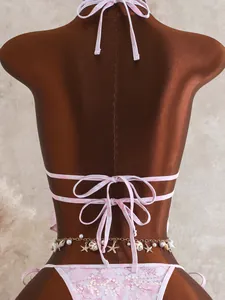 Detailweergave van de achterkant van roze bloemenhalterbikini met lovertjes