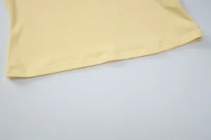 Detailed macro view of the ribbed knit fabric and durable hem stitching on a yellow halter top