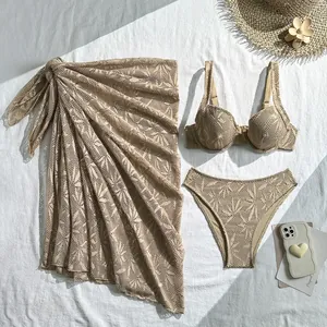 Detail view of beige three-piece crochet lace bikini set with matching beach wrap skirt