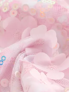 Detail van roze 3D bloemapplicaties en iriserende lovertjes op mesh badmode stof
