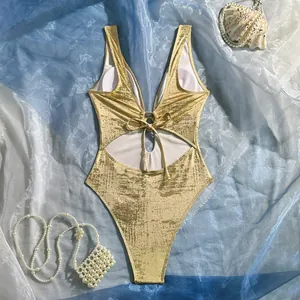 Detail view of gold metallic one-piece swimsuit with sexy cutout and lace-up front design