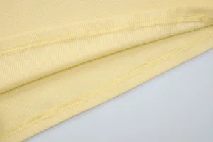 Close-up of yellow ribbed fabric showing high-quality double-needle stitching detail