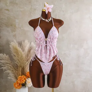 Gedetailleerd overzicht van de roze bloemen pailletten bikini op een bruine paspop