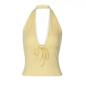 Close-up of yellow halter top featuring delicate white lace trim and front tie detail