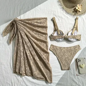 Detailed view of sand-colored hollow lace three-piece bikini set with matching sarong.