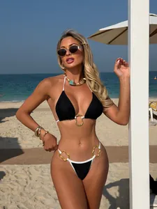 Detailed view of sexy black lace bikini set with gold hardware on a beach model