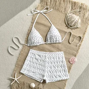 Detalle del conjunto de bikini blanco con lunares y volantes en una alfombra