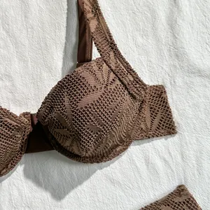 Macro view of brown hollow lace crochet bikini top featuring intricate knit details