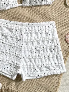 Detalle de braguita de bikini blanca con lunares y volantes suaves