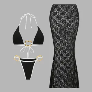 Three-piece black bikini set with gold heart rings and long lace cover-up skirt