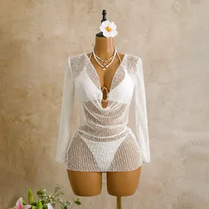 Detail showing white sequined mesh texture and cowl neck of long sleeve three-piece swimsuit