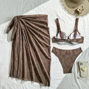 Close-up of coffee brown hollow-out palm leaf lace bikini set with matching sarong