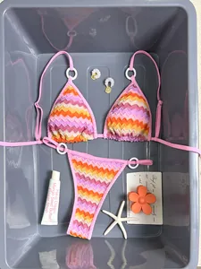 Vibrant gradient chevron bikini set with white ring details and summer accessories.