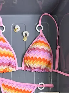 Detailed macro view of a colorful striped gradient bikini top with zigzag knit pattern.