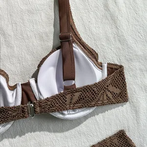 Close-up of the interior lining and intricate lace detail on a brown bikini top.