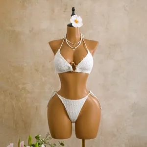 Close-up of white textured bikini set with heart-shaped ring detail on mannequin.