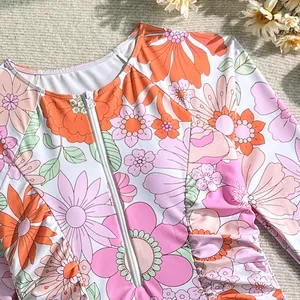 Detail of a floral long-sleeved swimsuit featuring a sturdy front zipper closure.
