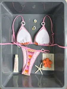 Detail view of pink gradient bikini set with white ring accents and chevron patterns
