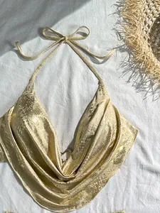 Hochwertiges Detail eines sexy goldfarbenen Bikini-Oberteils mit Wasserfallausschnitt