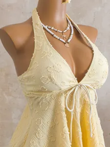Close-up view of textured yellow tankini top featuring halter neck and drawstring detail