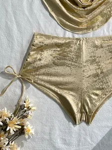 Detailansicht der champagnergoldenen Metallic-Struktur und Schnürung der Bikinihose