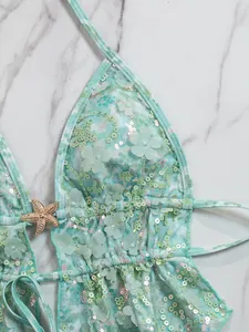 Detail van bloemen kant bikini topje met pailletten en decoratieve zeester.