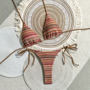 Bohemian striped knit bikini set with tie-side bottoms on decorative woven mats