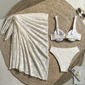 Three-piece ivory lace bikini set with matching sarong wrap for luxury beach vacation.