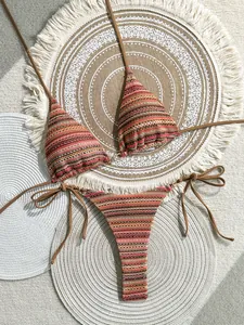 Bohemian striped crochet bikini set laid flat on woven decorative beach mats