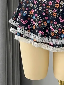 Close-up detail of ruffled floral bikini bottom with delicate white lace trim hem
