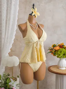 Detailed close-up of a yellow textured tankini swimsuit with ruffle hem shown on mannequin