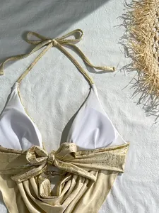 Nahaufnahme eines goldenen Metallic-Bikini-Tops mit Neckholder und Dekoschleife