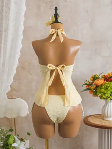 Back view of elegant yellow textured floral tankini swimsuit featuring a halter neck tie