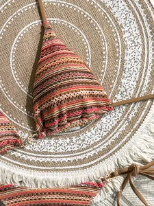 Macro detail of the bohemian knit texture on a striped color-block triangle bikini top
