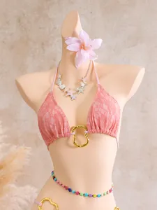 Detailed macro shot of pink lace mesh bikini top featuring unique golden metal hardware