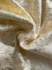 Detailansicht des schimmernden Goldfolien-Stoffs, der für luxuriöse Bikinis verwendet wird.